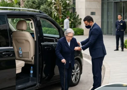 النقل الآمن في وضعية الجلوس: سائق يساعد مريضاً على الجلوس في سيارة واسعة نحو مصحة بالرباط